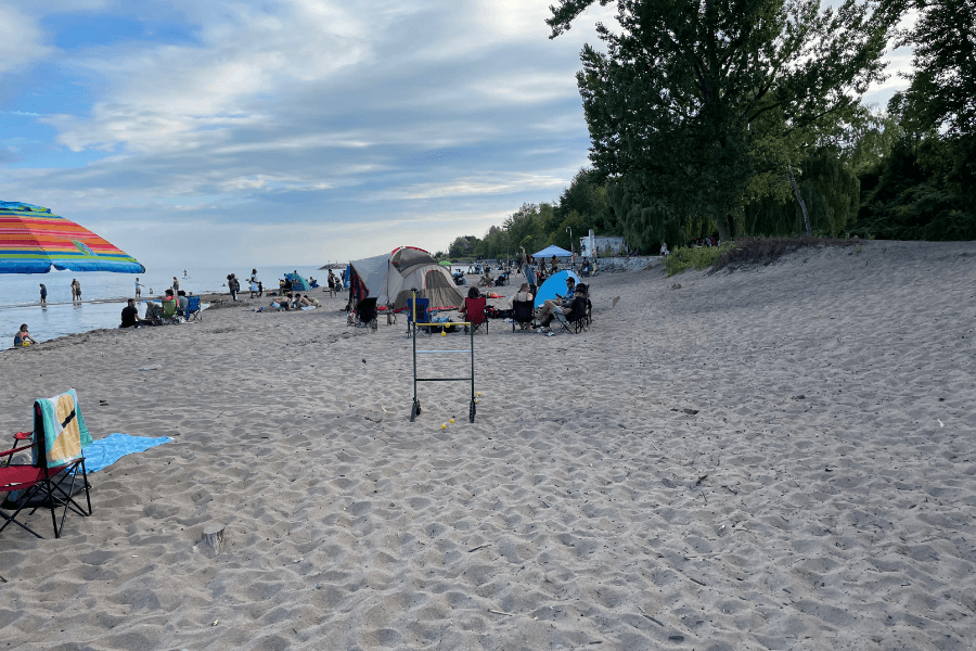 Umbrellas and tens set up at a sandy Lake Ontario beach.